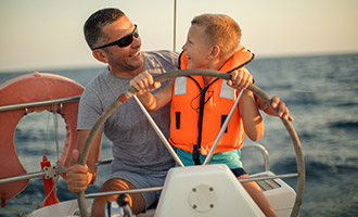 A father and son on a boat out at sea.